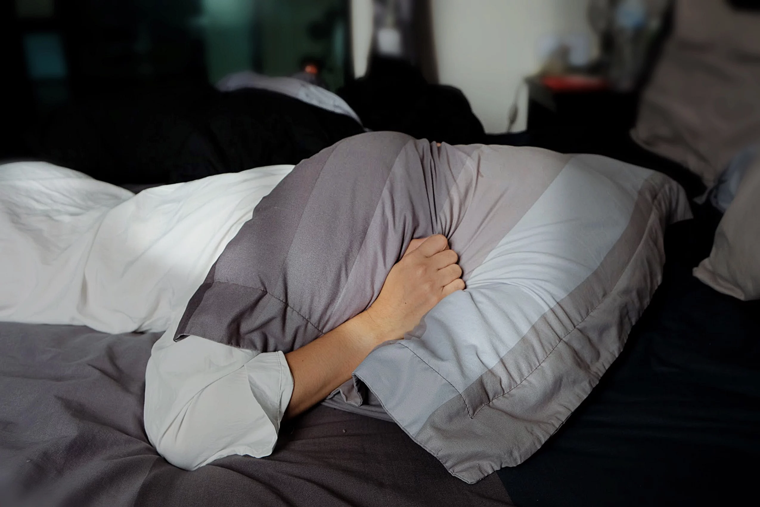 woman with head under pillow