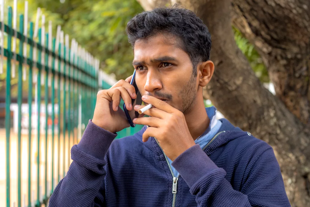 indian man smoking on phone